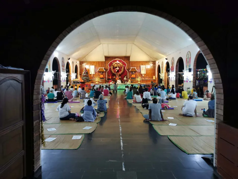Blick durch einen Torbogen in die Yogahalle des Ashrams