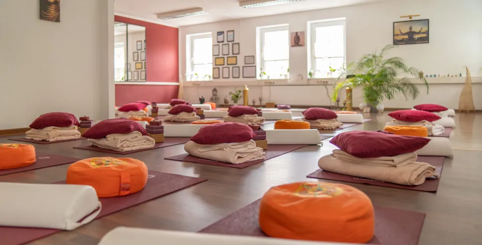Blick durch den Yogaraum mit roten Akzenten