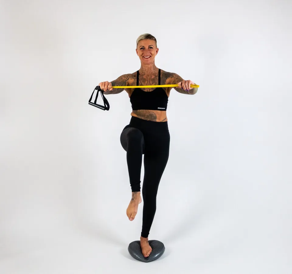 Kati trainiert auf dem Balancekissen mit Theraband