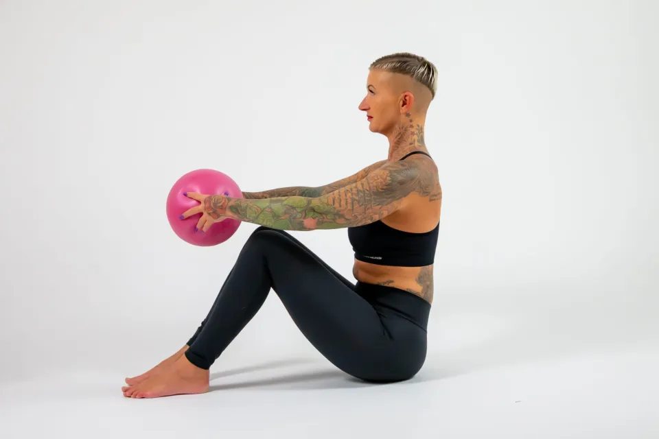 Kati trainiert im Sitzen mit kleinem Ball