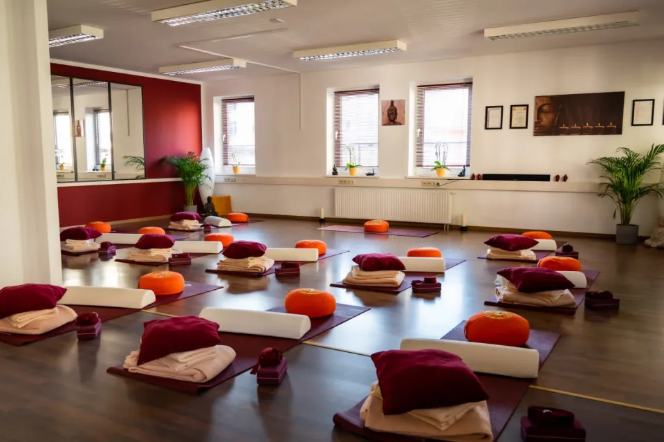 Heller Yogaraum mit vorbereiteten Matten und Kissen